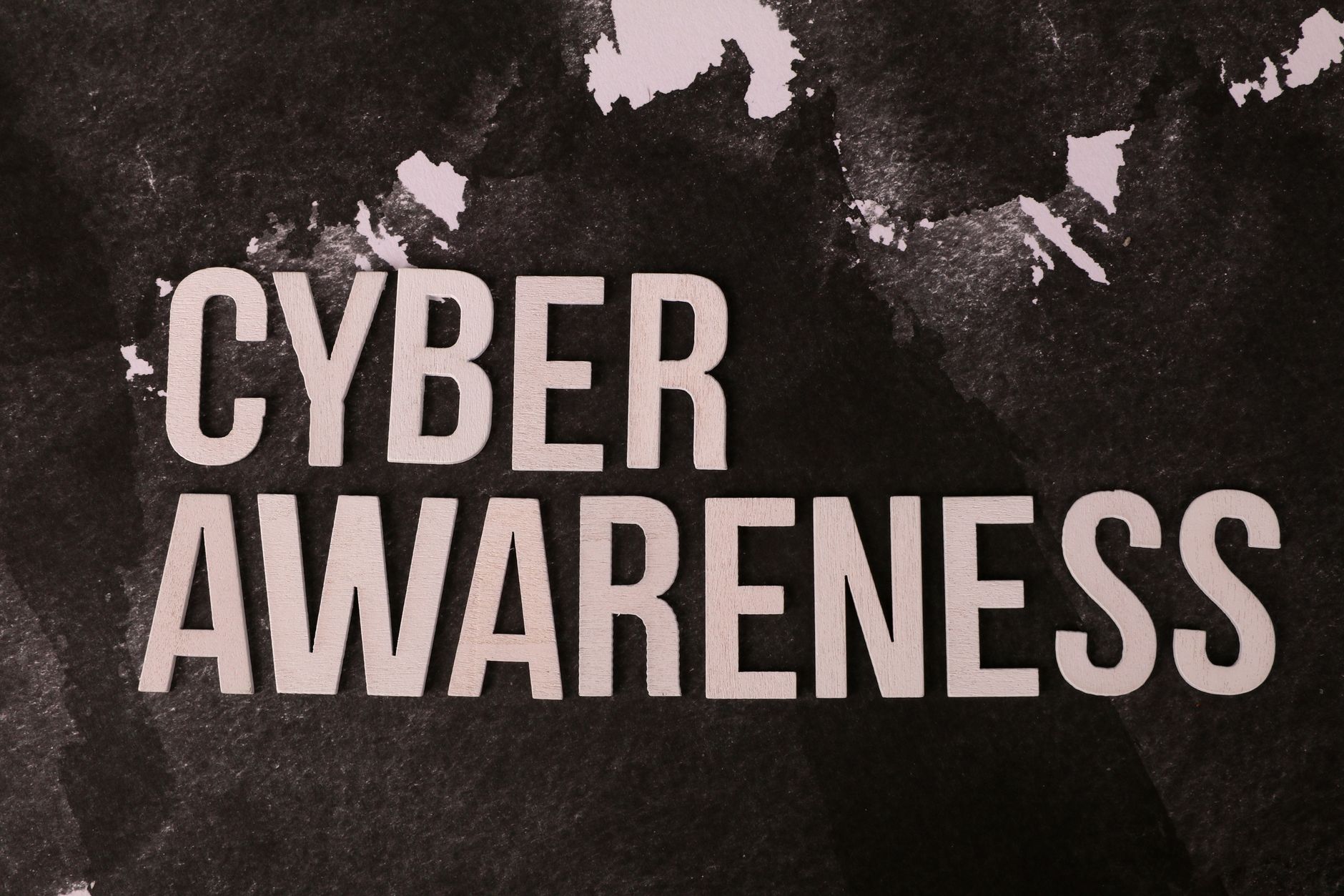 Stylized text 'Cyber Awareness' over abstract dark background, highlighting online safety theme.