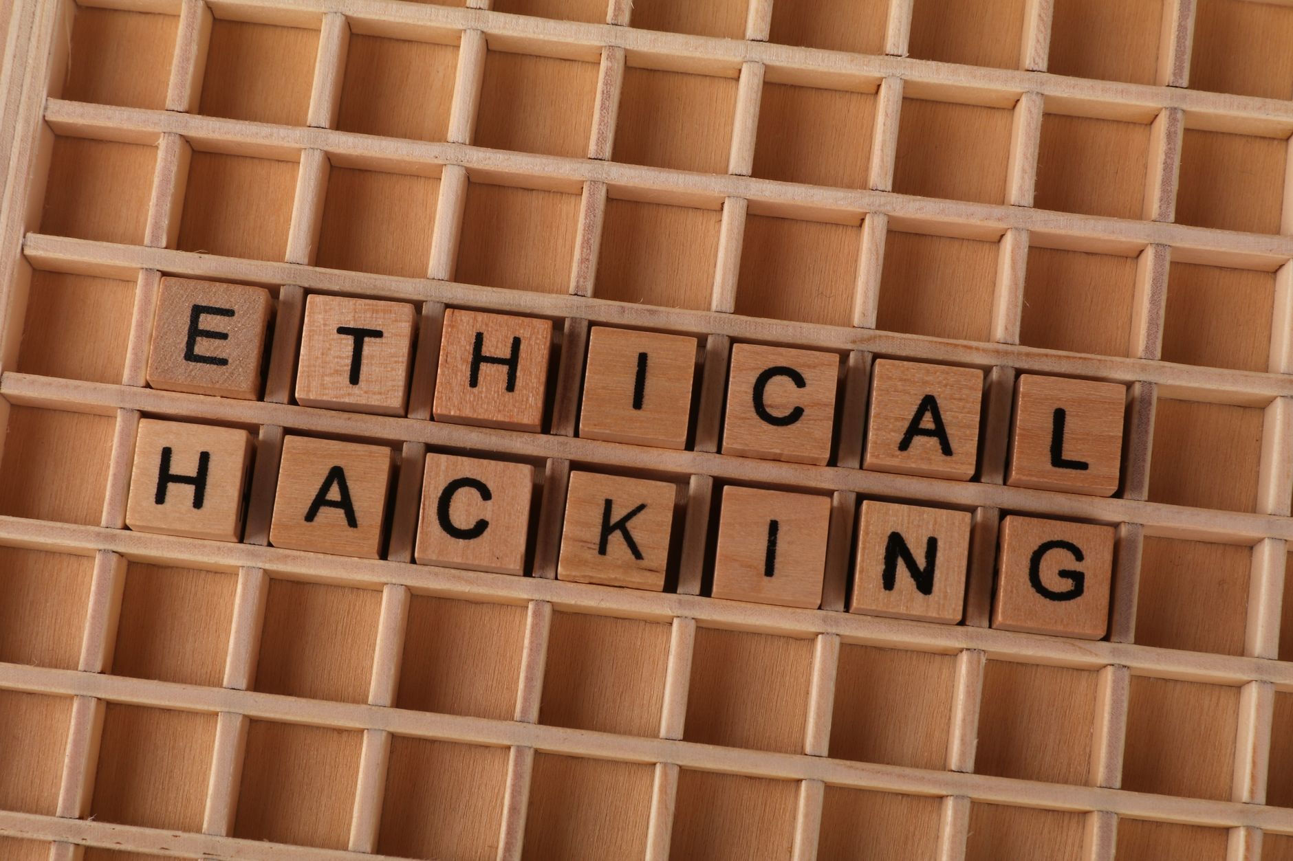 Wooden blocks spell 'ethical hacking', symbolizing cybersecurity concepts.