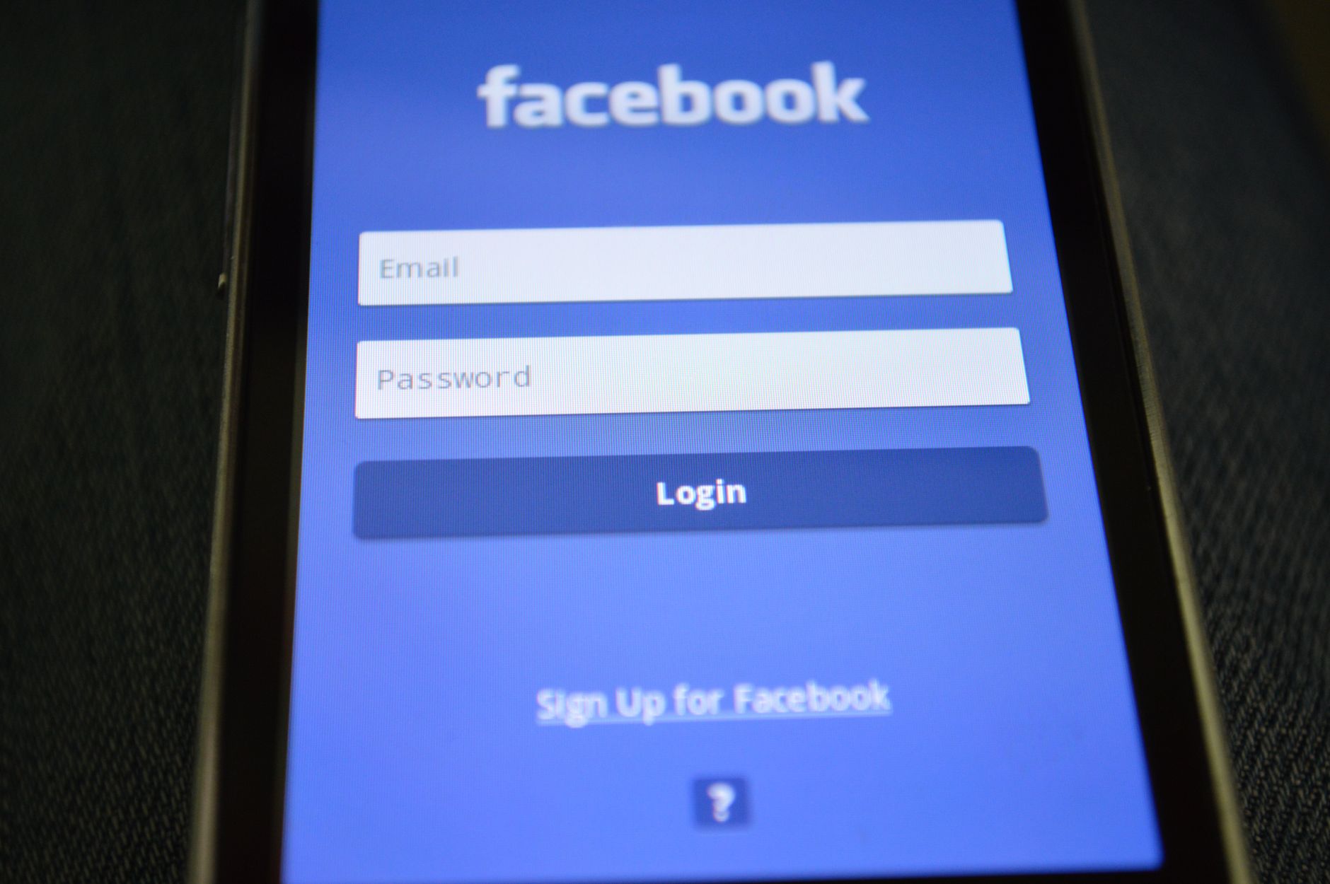 Close-up of a smartphone screen showing the Facebook login interface.