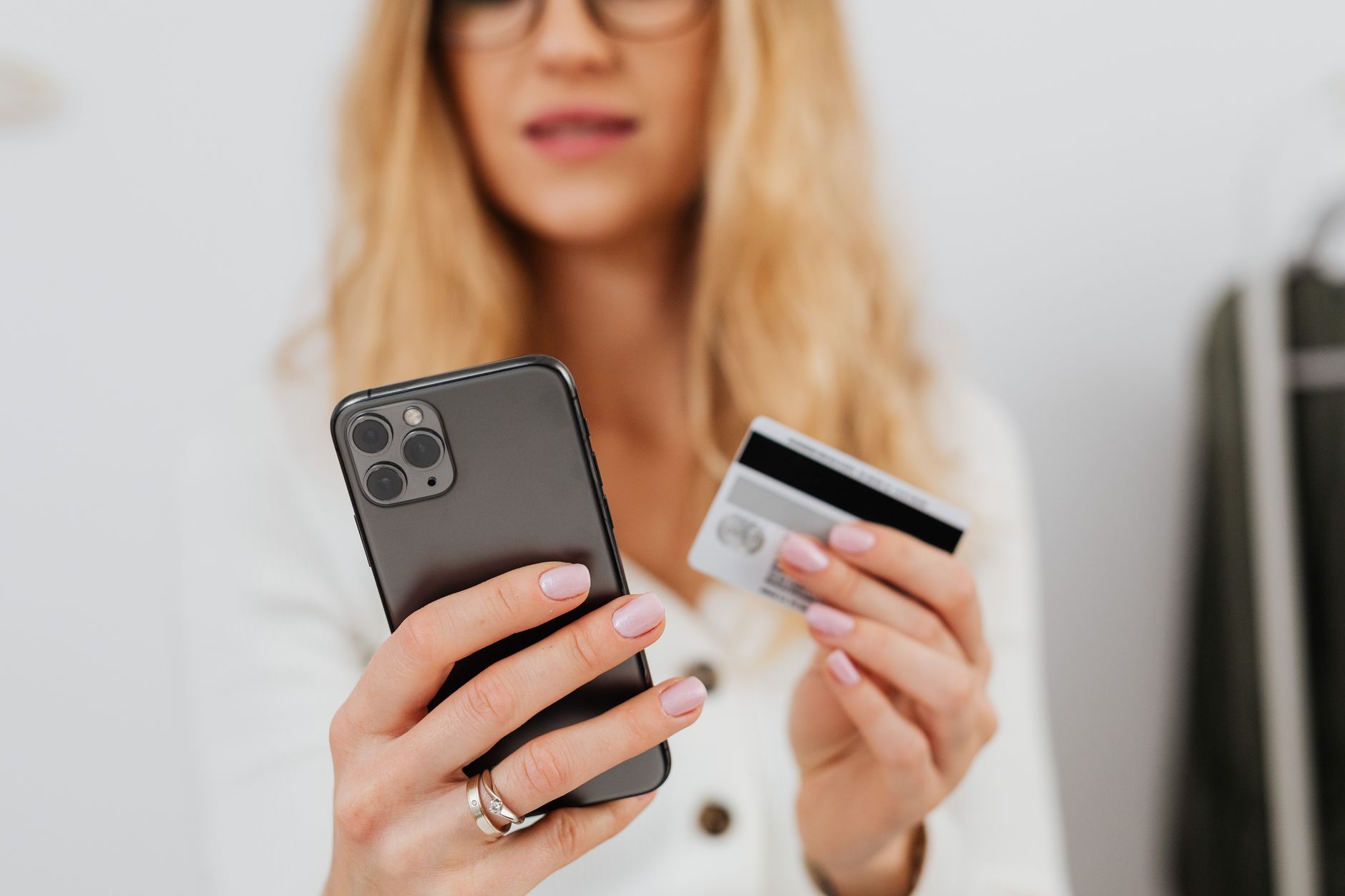 Close-up of a woman using a smartphone and credit card for online shopping.